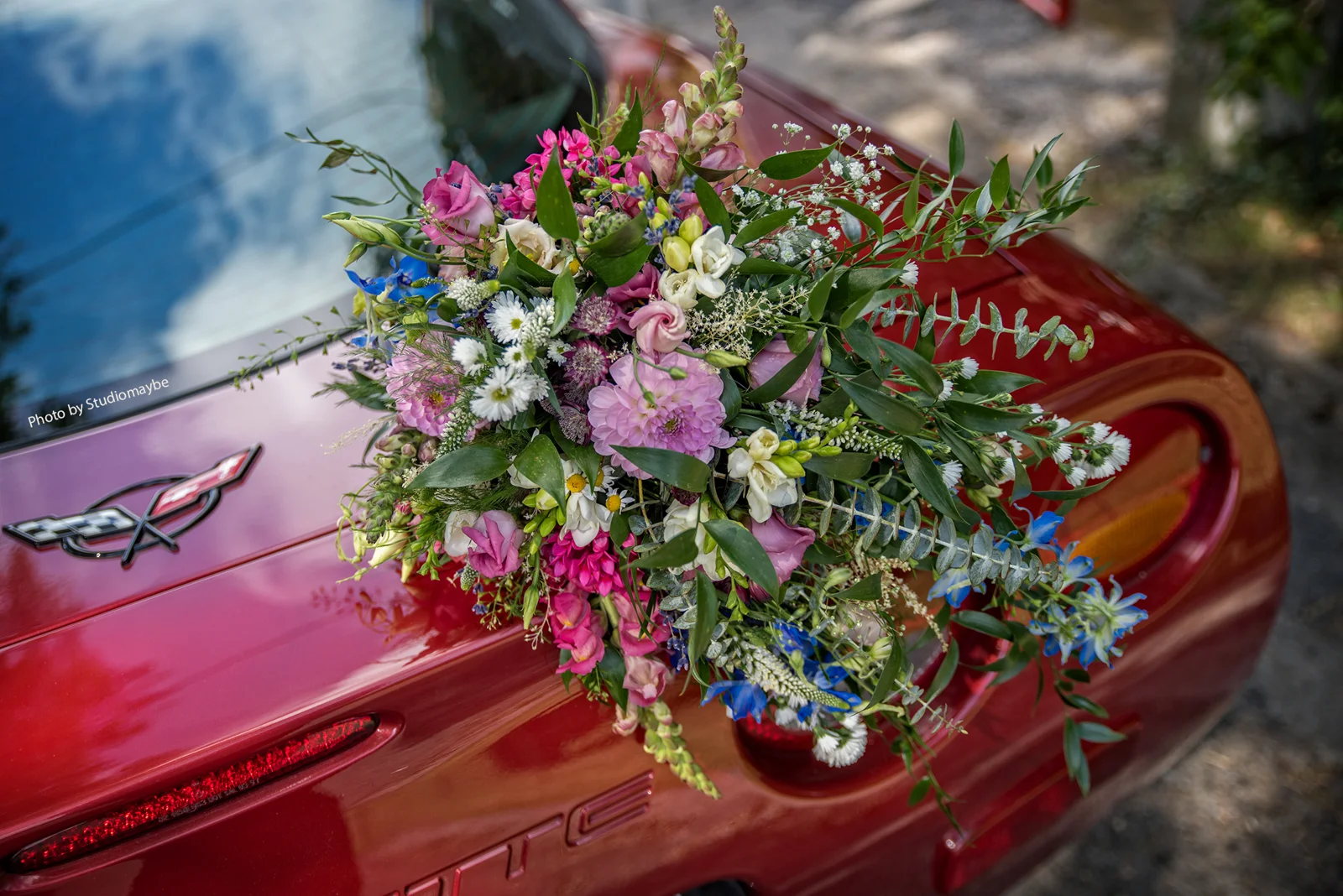 Bouquet de mariage sur une voiture rouge — Eric Bomal